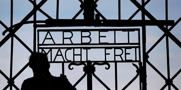 A blacksmith prepares a replica of the Dachau Nazi concentration camp gate, with the writing