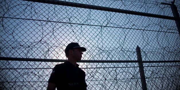 TOPSHOT - A Bulgarian border police personel patrols next to a barbed wire wall fence erected on the Bulgaria-Turkey border near the town of Lesovo, on September 14, 2016. / AFP / NIKOLAY DOYCHINOV (Photo credit should read NIKOLAY DOYCHINOV/AFP/Getty Images)