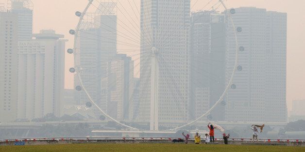 People take photos near the Singapore Flyer observatory wheel shrouded by haze August 26, 2016. REUTERS/Edgar Su TPX IMAGES OF THE DAY