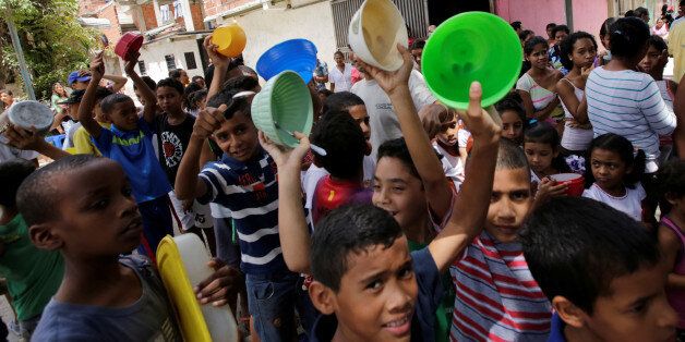 Children queue to wait to receive free food which was prepared by residents and volunteers on a street in the low-income neighborhood of Caucaguita in Caracas, Venezuela September 17, 2016. REUTERS/Henry Romero