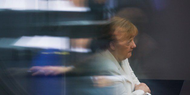 CORRECTS DATE In this photo taken through windows at the visitors tribune, German Chancellor Angela Merkel attends a debate about a package of new measures to help fight terrorism at the German parliament Bundestag in Berlin, Thursday, June 9, 2016. (AP Photo/Markus Schreiber)