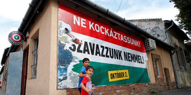 Hungarian Roma boys walk in front of the Hungarian goverment's poster regarding referendum on EU migrant quotas in Budapest, Hungary, September 28, 2016. Picture taken September 28, 2016. The poster reads: