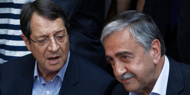 Cyprus President Nicos Anastasiades, left, and Turkish Cypriot leader Mustafa Akinci, speak as they sit at a coffee shop at the Turkish Cypriot breakaway northern part of the Cypriot divided capital Nicosia on Saturday, May 23, 2015. Cyprusâ rival Greek and Turkish Cypriot leaders took a stroll together on both sides of the divided capitalâs medieval center to raise the feel-good factor as talks aimed at reunifying the ethnically split island kick into gear. Itâs the first time that the leaders have done so together since the east Mediterranean island was split in 1974 when Turkey invaded after coup by supporters of union with Greece. (AP Photo/Petros Karadjias)