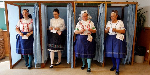 Hungarian women wearing traditional costume leave a voting booth at a polling station during a referendum on EU migrant quotas in Veresegyhaz, Hungary, October 2, 2016. REUTERS/Bernadett Szabo TPX IMAGES OF THE DAY