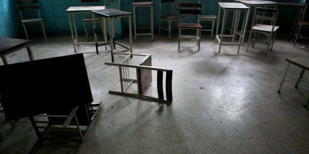 In this June 1, 2016 photo, desks and chairs sit in an abandoned classroom at a public high school in Caracas, Venezuela. Officially, Venezuela canceled 16 school days this year, including Friday classes because of an energy crisis. In reality, Venezuelan children are now missing an average of 40 percent of class time, a parent group estimates, and a third of teachers skip work on any given day to wait in food lines. (AP Photo/Ariana Cubillos)
