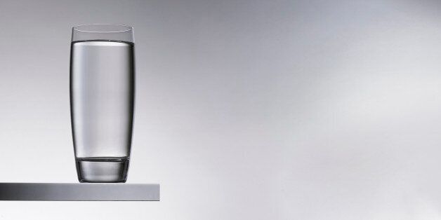 Glass of water on shelf.