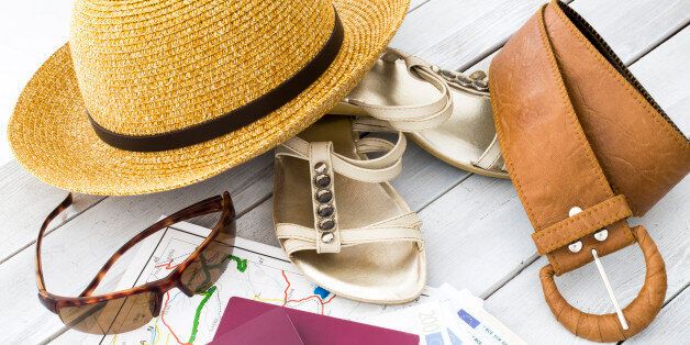 Travel concept. Travel items, straw hat, passport and money on wooden table