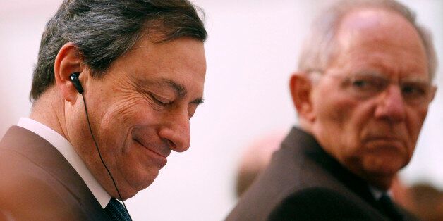 Mario Draghi, president of the European Central Bank (ECB), left, listens as Wolfgang Schaeuble, Germany's finance minister, gestures during the 'Ludwig Erhard Lecture' event in Berlin, Germany, on Thursday, Dec. 15, 2011. Draghi said there is no 'external savior' for countries that don't implement structural reforms to restore confidence to debt markets. Photographer: Michele Tantussi/Bloomberg via Getty Images