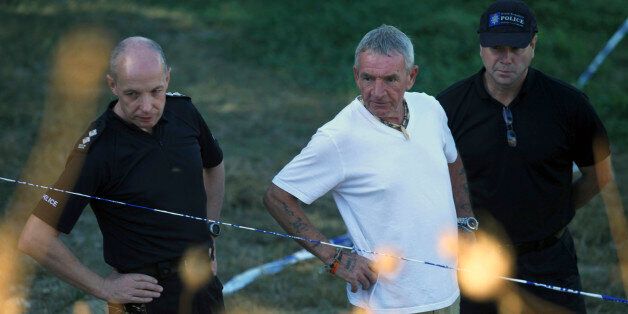 Eddie Needham (C), grandfather of Ben, is flanked by British police officers during a search operation for the remains of British boy Ben Needham in an area on the Greek island of Kos October 20, 2012. An extensive search was carried out 21 years ago when Needham went missing near the home where his grandparents and mother were holidaying in the island of Kos. A new search began on Friday to look for the body of the Sheffield-born boy. REUTERS/Yiannis Panagopoulos (GREECE - Tags: CRIME LAW)