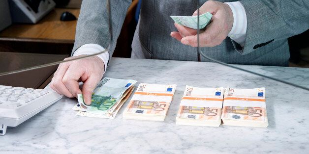 Bank teller counting Euro notes, mid section