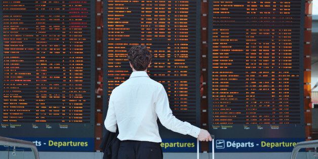 passenger looking at timetable board at the airport