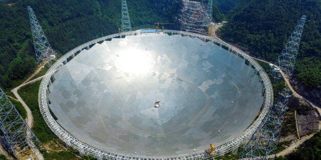 A 500-metre (1,640-ft.) aperture spherical telescope (FAST) is seen at the final stage of construction, among the mountains in Pingtang county, Guizhou province, China, May 7, 2016. REUTERS/Stringer ATTENTION EDITORS - THIS IMAGE WAS PROVIDED BY A THIRD PARTY. EDITORIAL USE ONLY. CHINA OUT. NO COMMERCIAL OR EDITORIAL SALES IN CHINA. TPX IMAGES OF THE DAY