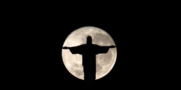 The full moon is pictured behind the Christ the Redeemer statue ahead of the 2016 Rio Olympic games in Rio de Janeiro, Brazil, July 19, 2016. REUTERS/Bruno Kelly TPX IMAGES OF THE DAY