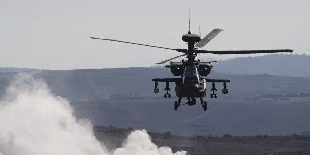 An AH-64 Apache helicopter flies over smoke while taking part in Exercise Trident Juncture 2015, NATO's largest joint and combined military exercise in more than a decade, at the San Gregorio training grounds outside Zaragoza, Spain, November 4, 2015. Some 36.000 personnel from more than 35 nations, including all NATO Allies will have participated in Exercise Trident Juncture 2015 which began on 21 October, in Italy, Portugal and Spain, including their adjacent waters and airspace and runs till November 6. REUTERS/Paul Hanna