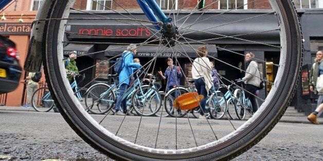 In this May 23, 2015 photo, a bike tour pauses in front of Ronnie Scott's jazz club in London. Traveling by bike is a great way for families to tour London together. (AP Photo/Ross D. Franklin)