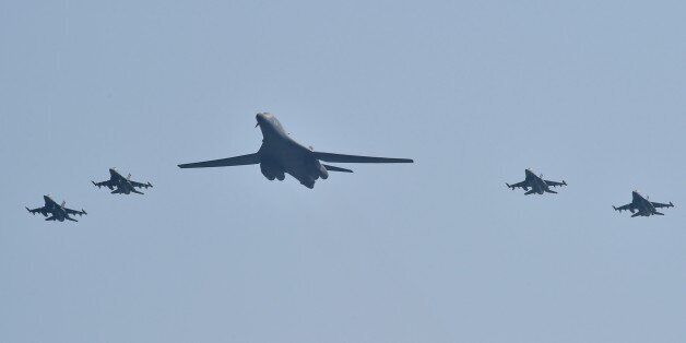 A US B-1B Lancer (C) is escorted by US F-16 fighter jets as it flies over the Osan Air Base, aiming at reinforcing the US commitment to its key ally in Pyeongtaek on September 13, 2016. / AFP / JUNG YEON-JE (Photo credit should read JUNG YEON-JE/AFP/Getty Images)