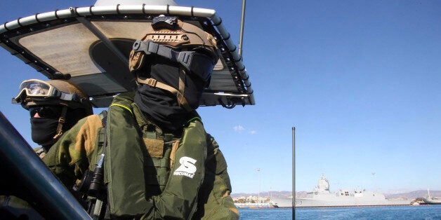 A member of the Norwegian Special Forces looks on during a sea patrol around a Norwegian frigate that docked at Limassol, December 14, 2013. A Danish-led task force was being readied in Cyprus on Saturday to remove the first part of Syria's deadly chemical stockpile, due before the end of this year. Under a deal worked out between the United States and Russia, Syria will relinquish control of deadly toxins which can be used to make sarin, VX gas and other lethal agents. Denmark and Norway plan to use two cargo vessels to transport the cargo out of the Syrian port city of Latakia, escorted by two frigates of their respective navies, and deliver it to the Organisation for the Prohibition of Chemical Weapons (OPCW) for destruction. REUTERS/Andreas Manolis (CYPRUS - Tags: MILITARY POLITICS)