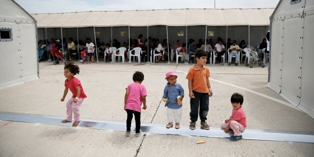 Children play as refugees and migrants wait to take part in a pre-registration process that gives them access to the asylum procedure, at the premises of the disused Hellenikon airport, in Athens, Greece, June 13, 2016. REUTERS/Alkis Konstantinidis