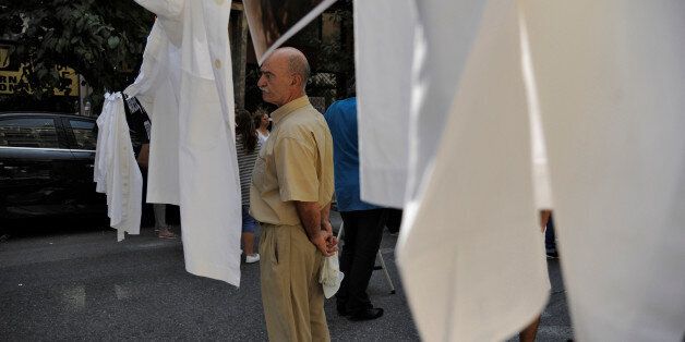 A health worker stands among pegged medical aprons during a demonstration against pension and tax reforms outside the Health Ministry in Athens, Greece June 29, 2016. REUTERS/Michalis Karagiannis