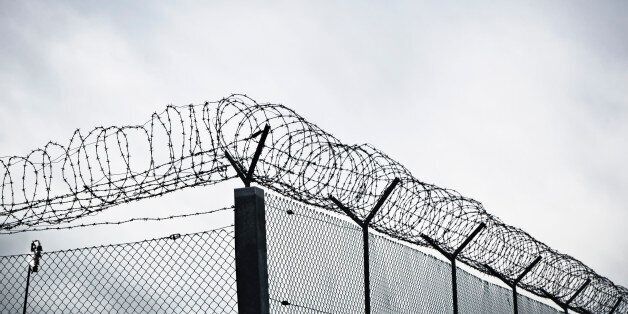 Chain link fence with barbed wire and razor wire.