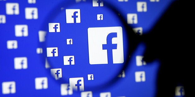 A man poses with a magnifier in front of a Facebook logo on display in this illustration taken in Sarajevo, Bosnia and Herzegovina, December 16, 2015. REUTERS/Dado Ruvic/Illustration/File Photo GLOBAL BUSINESS WEEK AHEAD PACKAGE - SEARCH