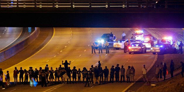 Police confront protesters blocking I-277 during demonstrations following Tuesday's police shooting of Keith Lamont Scott in Charlotte, N.C., Thursday, Sept. 22, 2016. (AP Photo/Gerry Broome)