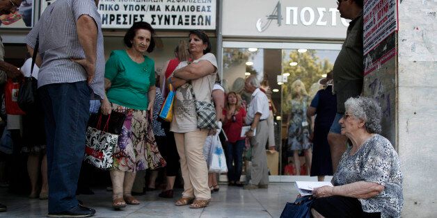 Pensioners wait outside Greece's largest Social Security Organisation (IKA) in Athens, Friday, May 31, 2013. Hundreds of retirees waited in line for hours outside IKA offices Friday, after missing a deadline to renew their pension registration as part of an effort in the bailed out country to combat benefit fraud. (AP Photo/Petros Giannakouris)