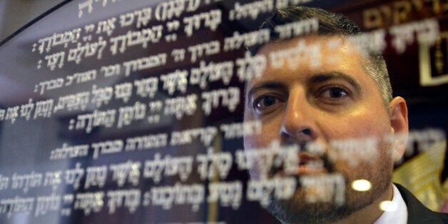 In this picture taken Friday, May 30, 2014, Csanad Szegedi waits in a Budapest Synagogue. Szegedi was a rising star of Hungaryâs far-right, dumped by his party after he admitted he was a Jew. Two years later, Csanad Szegedi has completed an astonishing transformation: He goes to synagogue, eats Kosher food and has adopted the Hebrew name Dovid. (AP Photo/Peter Kohalmi)