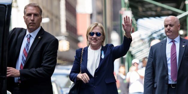 US Democratic presidential nominee Hillary Clinton waves to the press as she leaves her daughter's apartment building after resting on September 11, 2016 in New York.Clinton departed from a remembrance ceremony on the 15th anniversary of the 9/11 attacks after feeling 'overheated,' but was later doing 'much better,' her campaign said. / AFP / Brendan Smialowski (Photo credit should read BRENDAN SMIALOWSKI/AFP/Getty Images)