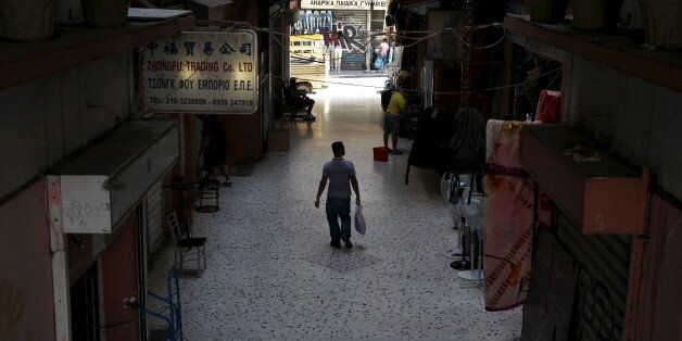 A man walks through a shopping arcade in central Athens, Greece, July 21, 2015. The Greek government submitted legislation to parliament on Tuesday required by its international lenders to start talks on a multi-billion euro rescue package. Prime Minister Alexis Tsipras has until Wednesday night to get those measures adopted in the assembly. A first set of reforms triggered a rebellion in his party last week and passed only thanks to votes from pro-EU opposition parties. REUTERS/Yiannis Kourtoglou TPX IMAGES OF THE DAY