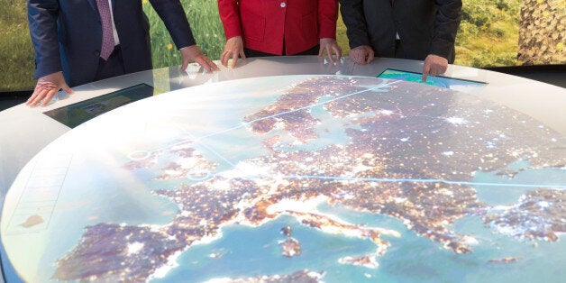 German chancellor Angela Merkel, center, European Parliament President Martin Schulz , right, and European Commission President Jean-Claude Juncker look at a map during the opening of an exhibition about Europe in Berlin Thursday May 12, 2016. (Michael Kappeler/Pool Photo via AP)