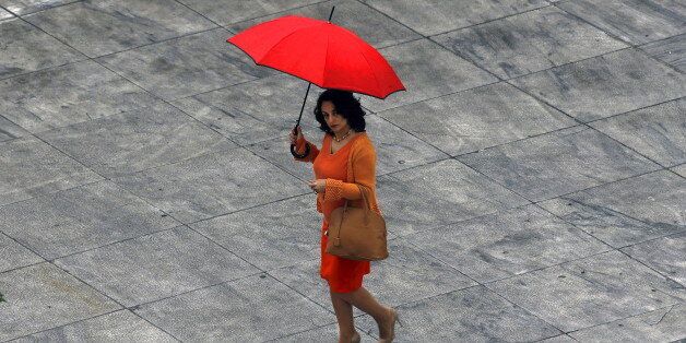 A woman walks through Athens' Syntagma (Constitution) square during a rainy Spring day March 26, 2015. REUTERS/Yannis Behrakis