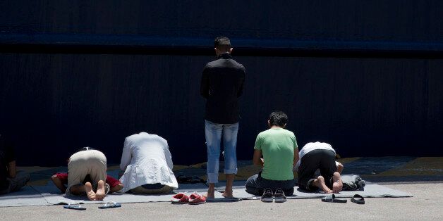 Afghan migrants stranded in Greece, pray in front of a docked ferry at the port of Piraeus, near Athens on the first day of the holy fasting month of Ramadan, Monday, June 6, 2016. During Ramadan, the holiest month in Islamic calendar, Muslims refrain from eating, drinking, smoking and sex from dawn to dusk. (AP Photo/Petros Giannakouris)
