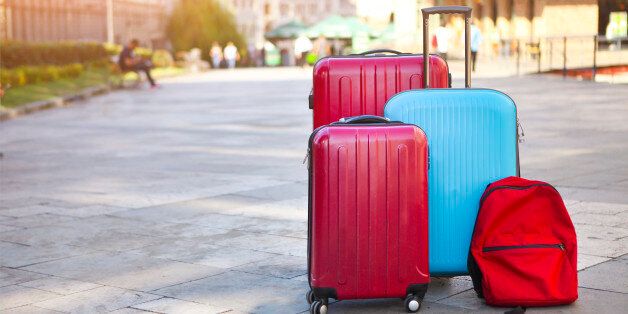 Luggage consisting of three large suitcases and travel backpack on the street. Holiday and travel concept
