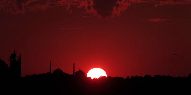 The sun sets behind Istanbul's skyline, Tuesday, July 14, 2015. Istanbul is a thoroughly modern place, but it traces its roots back to 660 B.C. Itâs the former seat of the opulent Byzantine and Ottoman empires and is divided into European and Asian sides by the Bosporus Strait, offering a wealth of history and stunning scenery. (AP Photo/Lefteris Pitarakis}