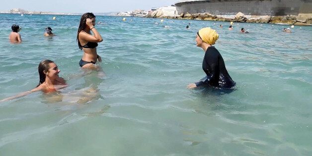 FILE - In this image Monday Aug. 29, 2016 file photo taken from video, Nesrine Kenza who says she is happy to be free to wear a burkini, and two unidentified friends wade into the sea, in Marseille, southern France. A French court has overturned Thursday Sept. 1, 2016 a ban on
