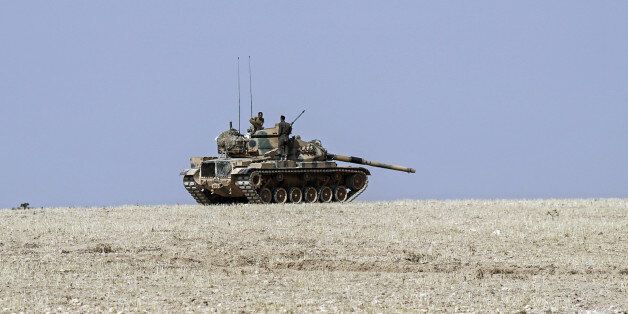A Turkish army tank stationed overlooks the Syrian border, in Karkamis, Turkey, Saturday, Aug. 27, 2016. Turkey on Wednesday sent tanks across the border to help Syrian rebels retake the key Islamic State-held town of Jarablus and to contain the expansion of Syria's Kurds in an area bordering Turkey.(AP Photo/Halit Onur Sandal)