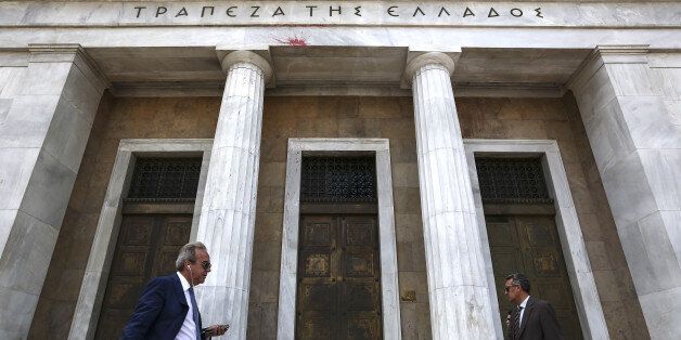 Pedestrians pass the entrance to the headquarters of the Bank of Greece in Athens, Greece, on Thursday, May 26, 2016. Greece may have passed a milestone and its bond market has been lucrative for some investors, but the road to recovery doesn't look much shorter. Photographer: Yorgos Karahalis/Bloomberg via Getty Images