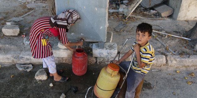 Children fill containers with water in the rebel held al-Maadi district of Aleppo, Syria, August 31, 2016. REUTERS/Abdalrhman Ismail
