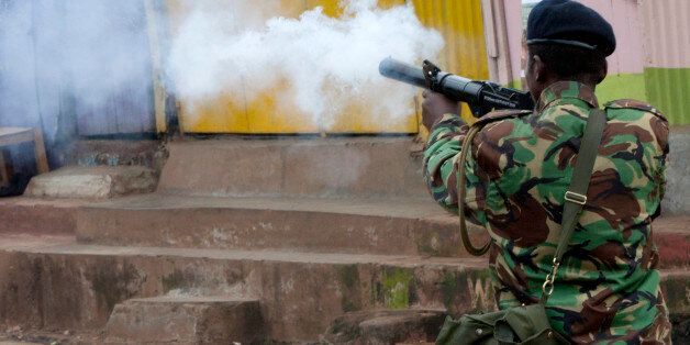 A riot police officer fires a teargas canister during a protest in Kibera Slums, Nairobi, Kenya Monday, May 23, 2016. The protests, held every Monday for the past four weeks, come before elections next year and are organized by Kenya's main opposition group the Coalitions for Reforms and Democracy. (AP Photo/Sayyid Azim)