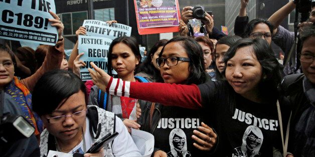 Indonesian maid Erwiana Sulistyaningsih, front right, waves to supporters as she arrives at a court in Hong Kong, Friday, Feb. 27, 2015. A Hong Kong court sentenced a mother of two to six years in prison on Friday for abusing her Indonesian maid in a case that triggered outrage over its brutality. Law Wan-tung was found guilty earlier this month on 18 charges, including assault, grievous bodily harm, criminal intimidation and failure to pay wages or give time off work to Sulistyaningsih. (AP Ph