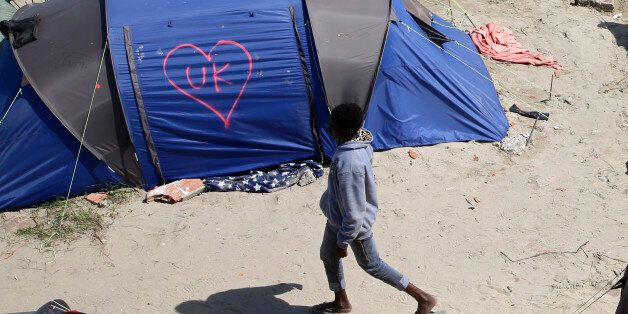 A heart and UK symbol are marked on the side of a tent as a migrant walks in the make-shift camp, called the jungle, in Calais, France, after Britain's referendum results to leave the European Union were announced June 24, 2016. REUTERS/Pascal Rossignol