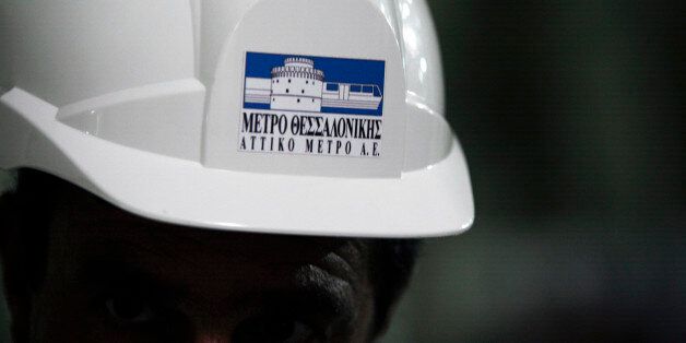 The logo of Attiko Metro SA, the state-controlled metro operator, sits on the safety helmet of a construction worker inside the new Panepistimio metro station, part developed by Aegek SA, in Thessaloniki, Greece, on Friday, Aug. 29, 2014. Two years ago, with Greece's euro membership in jeopardy and the currency region close to splintering, the government persuaded private bondholders to write down about 100 billion euros ($132 billion). Photographer: Konstantinos Tsakalidis/Bloomberg via Getty I