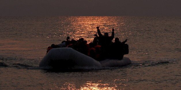 Refugees and migrants wave as they approach the shores of the Greek island of Lesbos on a dinghy during sunrise, March 20, 2016. REUTERS/Alkis Konstantinidis