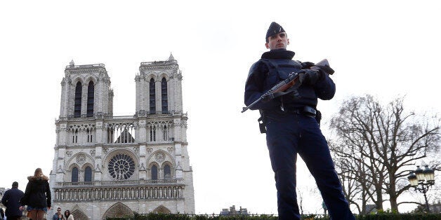 FILE - In this March 27, 2016 file photo, a French Police officer stands guards as worshipers arrive for the Easter mass at Notre Dame Cathedral, in Paris. Police officials say Wednesday Sept. 7, 2016 a terrorism investigation is under way into seven gas canisters found in a car parked near Notre Dame Cathedral in Paris. The car was discovered Sunday morning along the Seine River, with no one inside and no license plates but with the hazard lights on, the officials said Wednesday (AP Photo/Francois Mori, File)