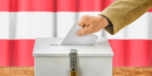 Man putting a ballot into a voting box - Austria