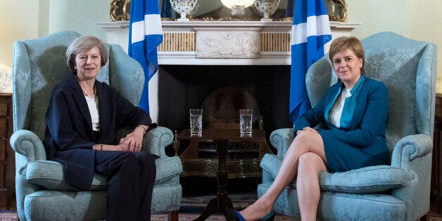 Britain's new Prime Minister Theresa May, left, meets with First Minister of Scotland, Nicola Sturgeon at Bute House in Edinburgh, Scotland, Friday July 15, 2016, with Scottish saltire flags behind. Prior to the meeting, May said