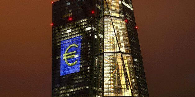 The headquarters of the European Central Bank (ECB) are illuminated with a giant euro sign at the start of the