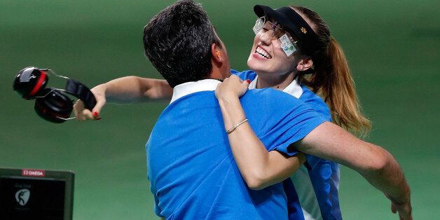 Anna Korakaki (R) of Greece hugs with her coach, also her father after the women's 25m pistol final of shooting at the 2016 Rio Olympic Games in Rio de Janeiro, Brazil, on Aug. 9, 2016. Anna Korakaki won the gold medal./ CHINA OUT