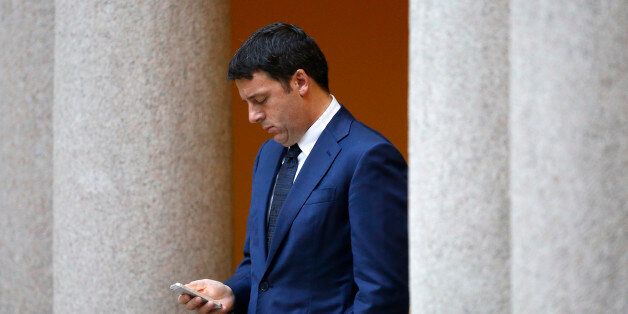 Italy's Prime Minister Matteo Renzi checks his phone as he waits for the arrival of leaders for a meeting, on the sidelines of the Europe-Asia summit (ASEM) in Milan October 17, 2014. REUTERS/Alessandro Garofalo (ITALY - Tags: POLITICS)